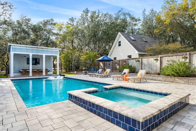 view of pool with a patio area, an outbuilding, and an in ground hot tub