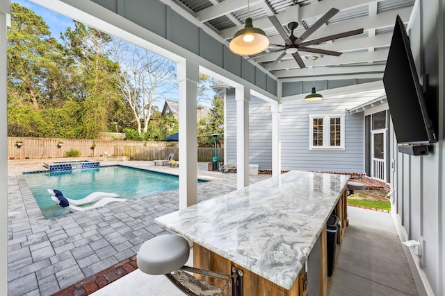 view of pool featuring ceiling fan, a bar, and a patio