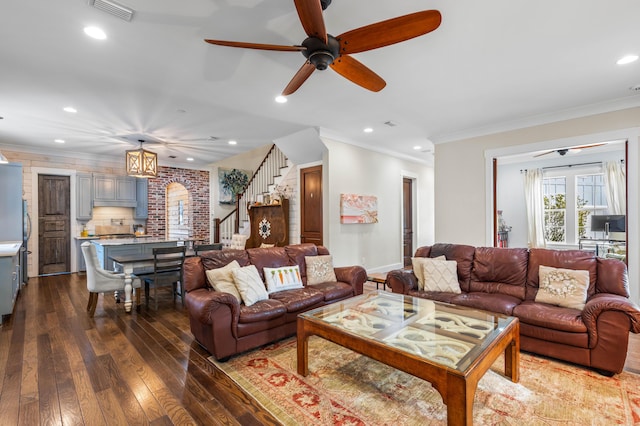 living room featuring ceiling fan with notable chandelier, hardwood / wood-style floors, and ornamental molding