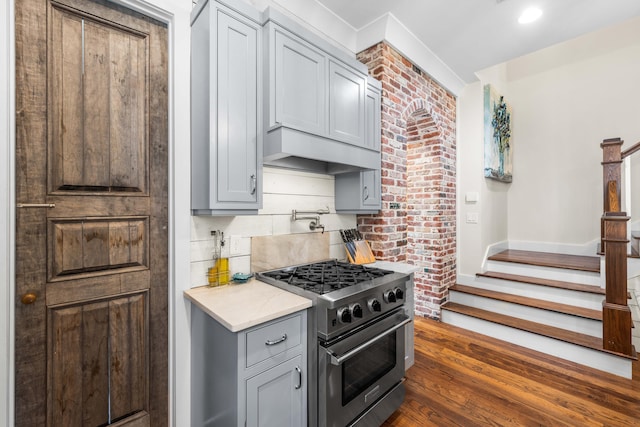 kitchen with custom exhaust hood, gray cabinets, backsplash, dark hardwood / wood-style flooring, and high end stainless steel range