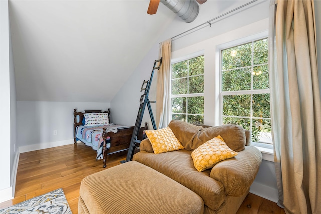 bedroom with ceiling fan, vaulted ceiling, and light hardwood / wood-style floors