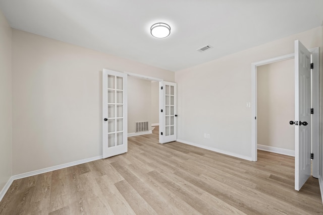 spare room with light hardwood / wood-style flooring and french doors