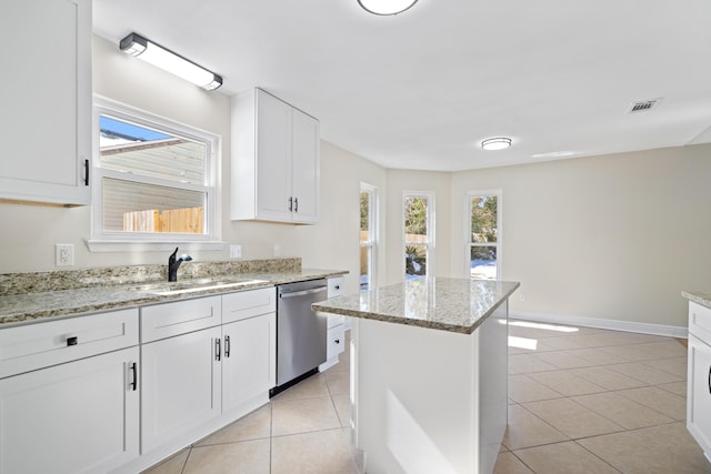 kitchen with a kitchen island, white cabinetry, dishwasher, sink, and light tile patterned floors