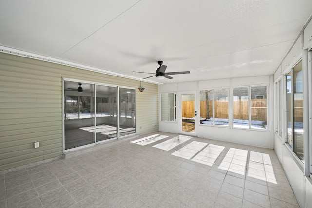 unfurnished sunroom featuring ceiling fan