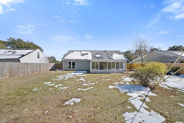 rear view of property featuring a yard and a sunroom