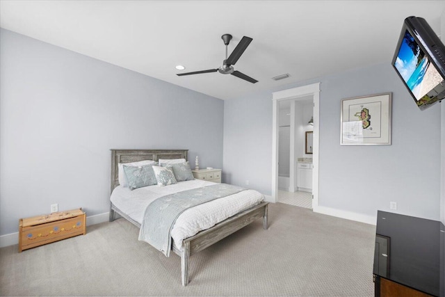 bedroom with carpet floors, ceiling fan, and ensuite bath