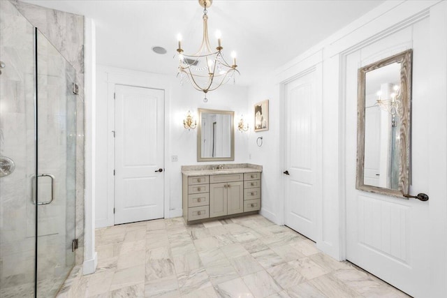 bathroom with vanity, an inviting chandelier, and a shower with shower door