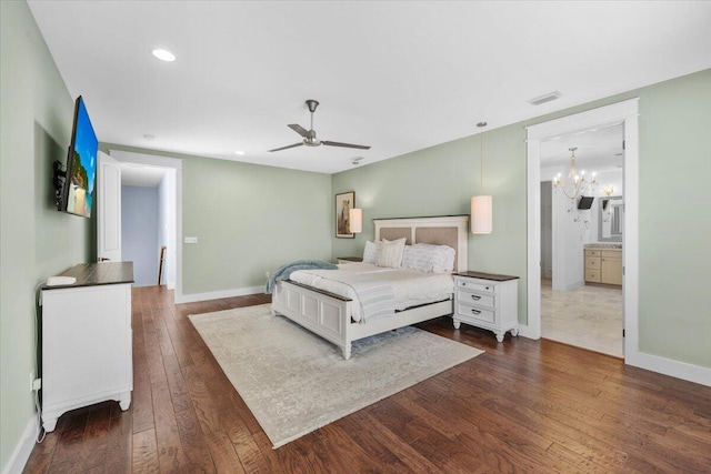 bedroom featuring ensuite bathroom, dark hardwood / wood-style floors, and ceiling fan with notable chandelier