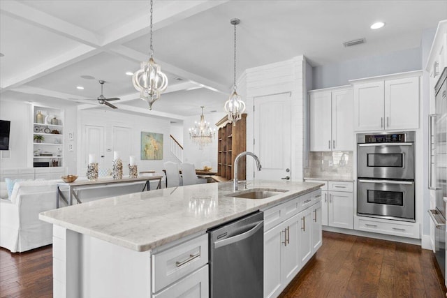 kitchen featuring sink, appliances with stainless steel finishes, white cabinetry, a kitchen island with sink, and hanging light fixtures