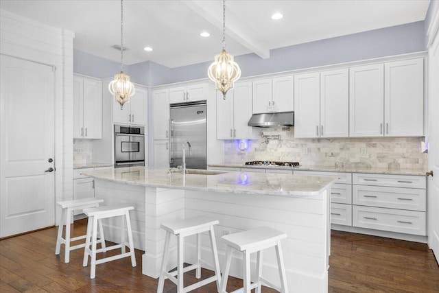 kitchen featuring white cabinetry, appliances with stainless steel finishes, sink, and an island with sink