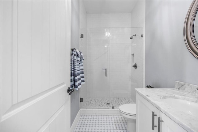 bathroom featuring vanity, a shower with shower door, and toilet