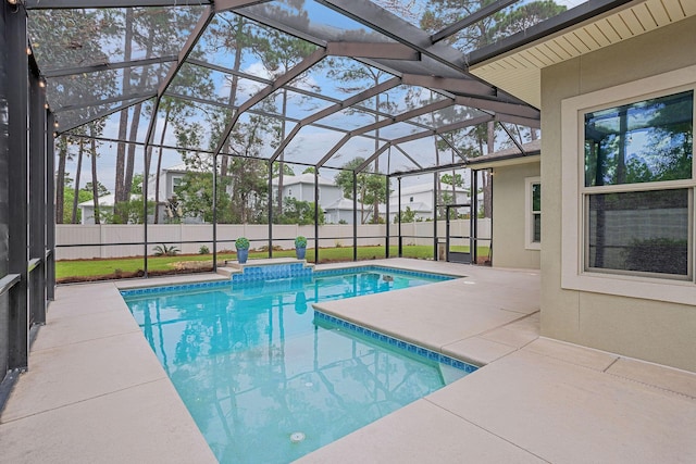 view of pool with glass enclosure and a patio