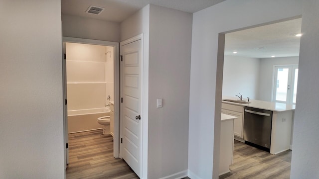 hall featuring sink and light hardwood / wood-style floors