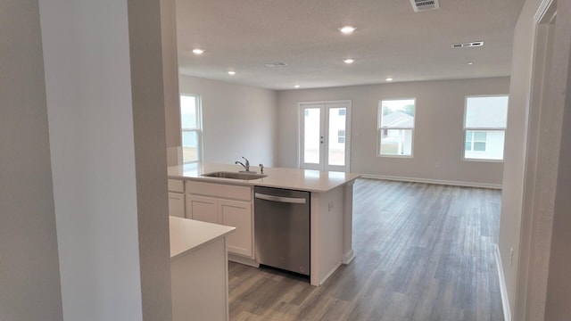 kitchen with white cabinetry, dishwasher, sink, an island with sink, and light wood-type flooring