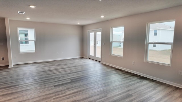 spare room with hardwood / wood-style flooring and a textured ceiling