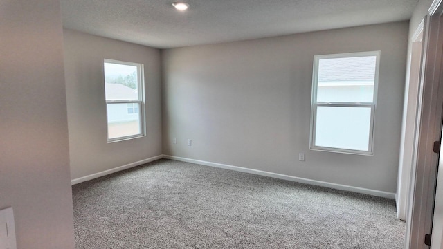 carpeted empty room with a textured ceiling