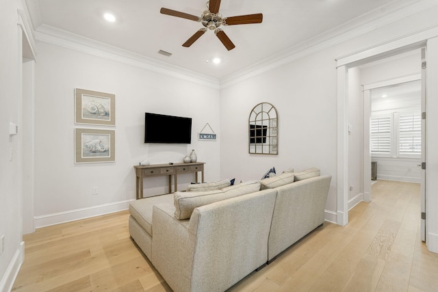 living room featuring ceiling fan, light wood-type flooring, and ornamental molding