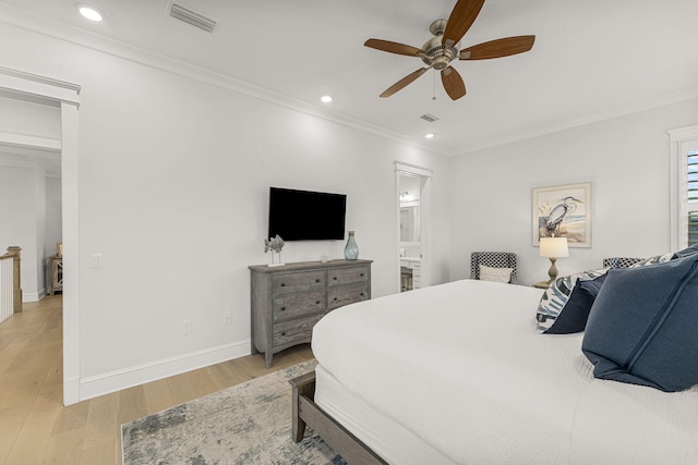 bedroom with ceiling fan, connected bathroom, light hardwood / wood-style flooring, and crown molding