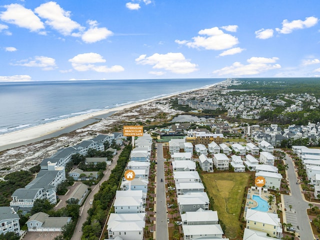 birds eye view of property with a water view and a beach view