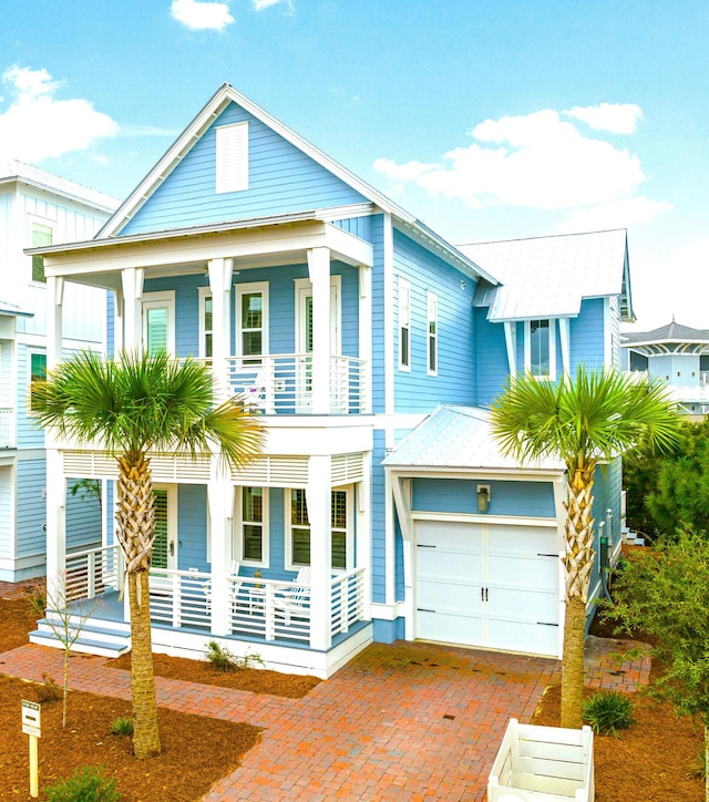 view of front of property featuring a balcony, a porch, and a garage