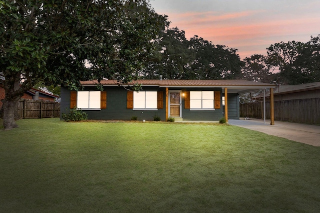 ranch-style home with a lawn and a carport