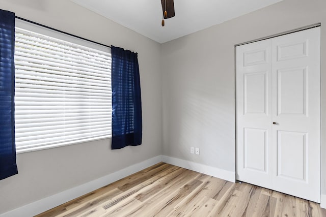 unfurnished bedroom featuring ceiling fan, light hardwood / wood-style floors, and a closet