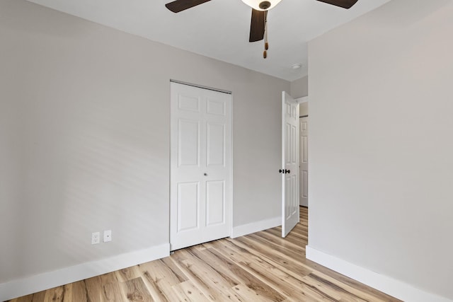 unfurnished bedroom featuring ceiling fan, a closet, and light hardwood / wood-style flooring