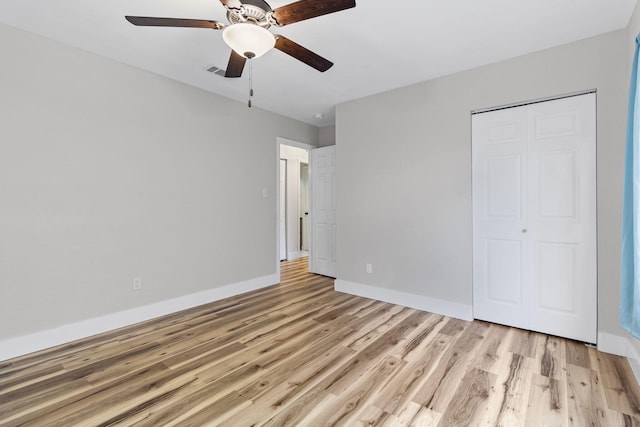 unfurnished bedroom featuring a closet, ceiling fan, and light wood-type flooring