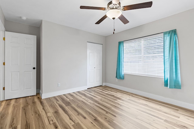 unfurnished bedroom featuring light hardwood / wood-style flooring, a closet, and ceiling fan