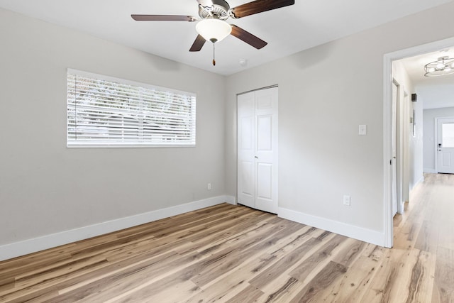 unfurnished bedroom featuring light hardwood / wood-style flooring, a closet, and ceiling fan