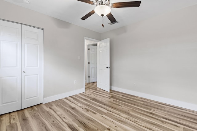 unfurnished bedroom with light hardwood / wood-style floors, a closet, and ceiling fan