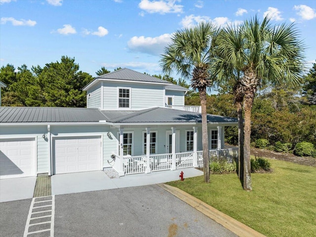 view of front of property with a garage, a front yard, and covered porch