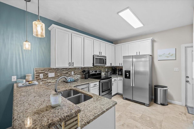 kitchen with appliances with stainless steel finishes, white cabinets, and decorative light fixtures