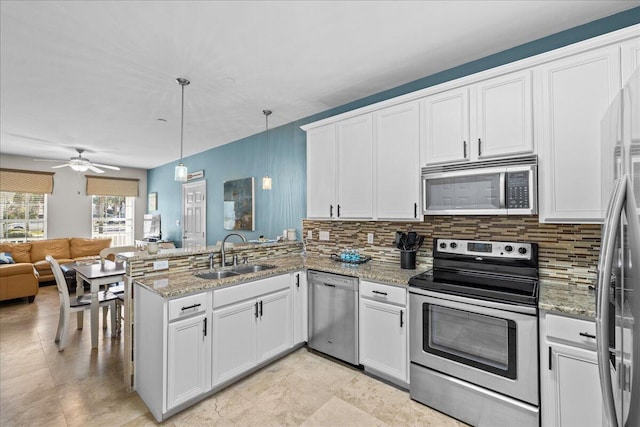 kitchen with decorative light fixtures, kitchen peninsula, sink, white cabinetry, and stainless steel appliances