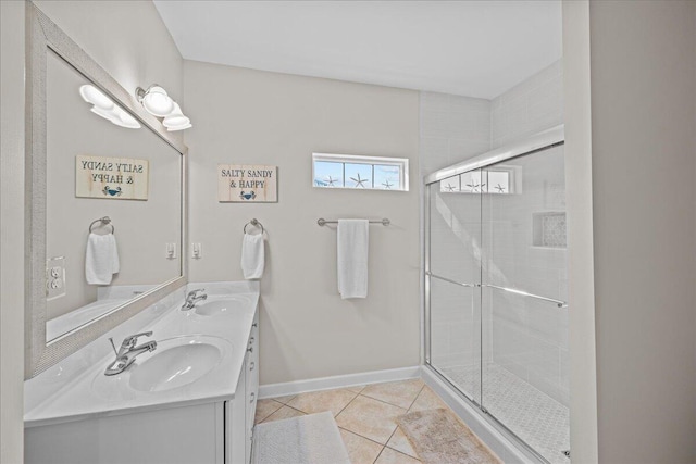 bathroom featuring a shower with shower door, vanity, and tile patterned floors