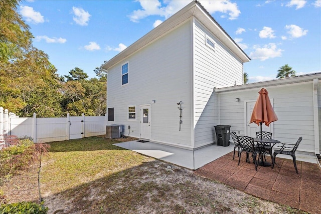 back of property featuring cooling unit, a yard, and a patio