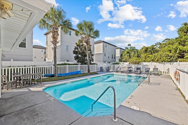 view of swimming pool featuring ceiling fan and a patio area