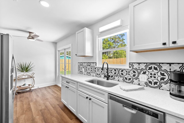 kitchen with ceiling fan, sink, light hardwood / wood-style flooring, appliances with stainless steel finishes, and white cabinets