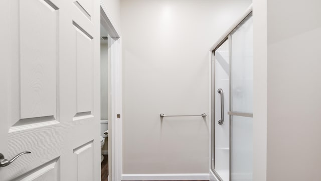 bathroom with an enclosed shower and toilet