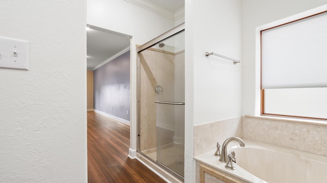 bathroom featuring crown molding, wood-type flooring, and shower with separate bathtub