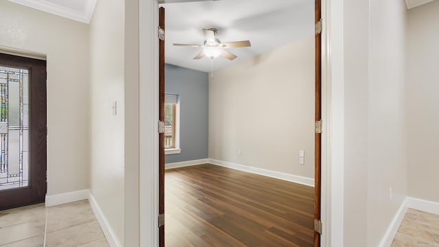 entryway with ornamental molding, a wealth of natural light, ceiling fan, and light hardwood / wood-style flooring