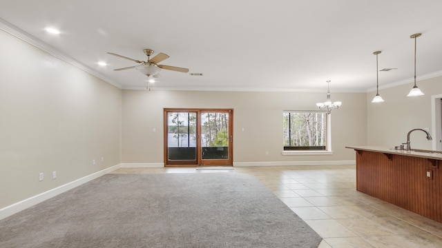 unfurnished living room featuring sink, crown molding, and a wealth of natural light