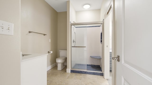 bathroom with toilet, vanity, tile patterned floors, and walk in shower