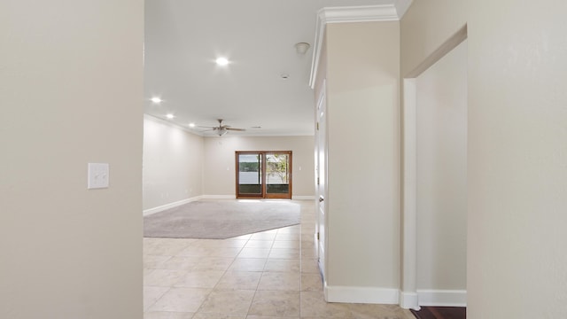 hall with ornamental molding and light tile patterned floors