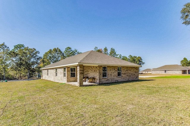 rear view of property with a lawn and a patio