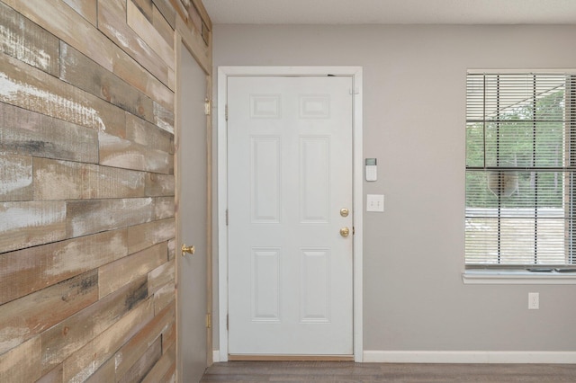 doorway to outside with hardwood / wood-style flooring, a healthy amount of sunlight, and wood walls