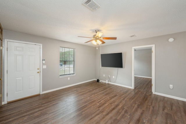 unfurnished living room with ceiling fan, dark hardwood / wood-style floors, and a textured ceiling