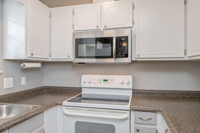 kitchen featuring white range with electric cooktop and white cabinets