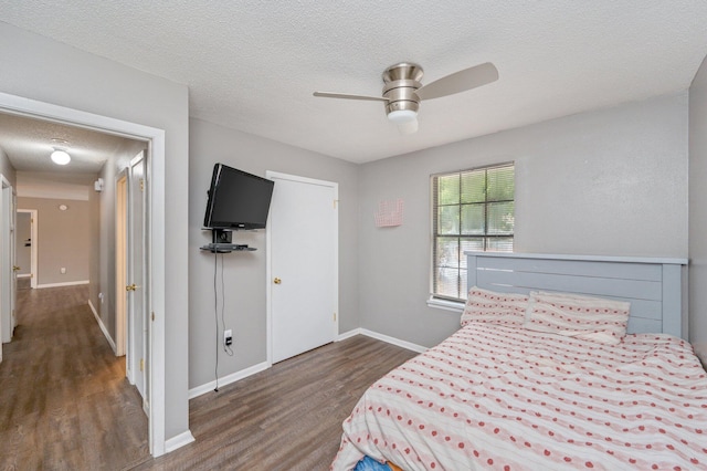 bedroom featuring ceiling fan, dark hardwood / wood-style floors, and a textured ceiling