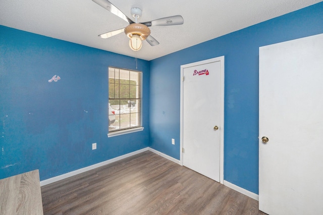 spare room with dark hardwood / wood-style floors and ceiling fan